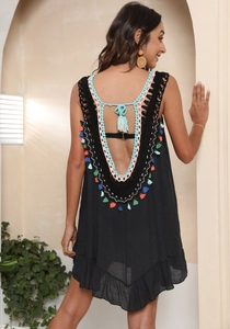 Detail of bohemian black backless dress featuring colorful crochet trim and mini tassels