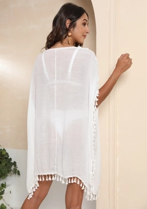 Détail du cache-maillot de plage blanc avec bordures à franges et tissu semi-transparent