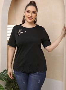 Détail du motif de rose ajourée découpé au laser sur l'épaule d'un t-shirt noir grande taille