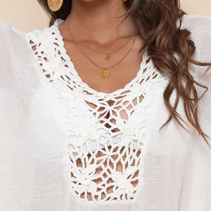 Détail du cache-maillot blanc bohème montrant des motifs floraux complexes et des textures