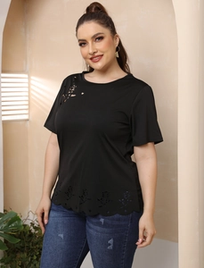Détails des motifs floraux découpés au laser sur un t-shirt noir grande taille