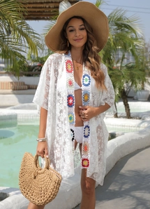Detailed crochet flower patterns on the front of this white lace beach cover-up