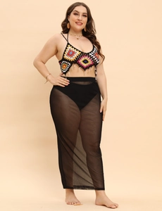 Detail of crochet halter top with colorful geometric patterns and sheer mesh maxi skirt