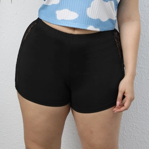 Gros plan du short noir taille haute avec détails latéraux en dentelle florale