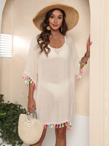 Detail of light beige beach cover-up featuring vibrant colorful tassel fringe on wide sleeves