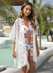 Close-up of white lace beach cover-up with colorful crochet granny square details