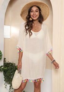Detail of colorful tassel trim on a beige beach cover-up with vibrant fringes