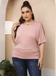 Detail view of ruched waist and cold shoulder sleeve design on a plus size pink top