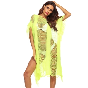 Detail of neon yellow knit beach cover-up with hollow out texture and fringe hem