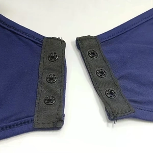 Macro-opname van de drievoudige drukknoopsluiting op een donkerblauwe stretch bodysuit