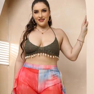 Close-up of handmade crochet halter top with sea shell tassels and tie-dye bohemian pants