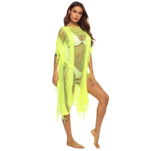 Detailed close-up of neon green knit beach cover-up with fringe and hollow texture