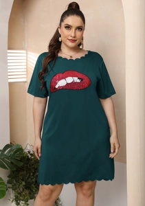 Détails de broderie à lèvres rouges et bordure festonnée sur la robe verte