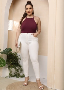 Detailweergave van bordeauxrode halter bodysuit met witte nauwsluitende hoge taille broek