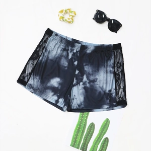 Détail du short tie-dye gris avec empiècements en dentelle florale noire et taille élastique