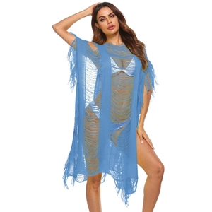 Detail of blue crochet beach cover-up with distressed hollow out texture and long tassels