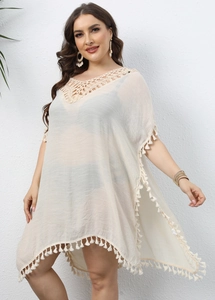 Détail de robe de plage au crochet col V avec bordures à franges et pompons blancs