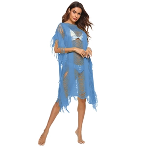Detailed close-up of blue hollow-out knit beach cover-up featuring long tassel fringe accents