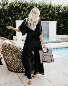 Detail of hollow lace crochet at the waist of a black long-sleeved sheer beach cover-up