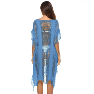 Close-up of blue crochet beach cover-up featuring open knit patterns and long fringe hem
