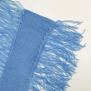 Detail of light blue knit fabric with dense tassels and smooth weaving texture
