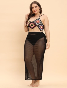 Detail of crochet knit crop top with colorful patterns and black mesh maxi skirt