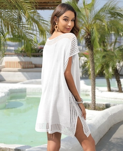 Close-up of white crochet beach cover-up featuring intricate hollow patterns and side slits