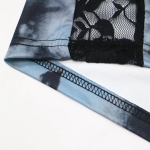 Détail de l'imprimé tie-dye avec empiècements en dentelle noire et coutures surjetées