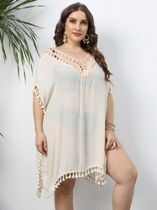 Détail de l'encolure en V crochetée bohème et texture tissée main sur le cache-maillot crème