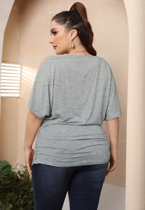 Detail view of plus size grey batwing sleeve top with side ruched texture and knit fabric