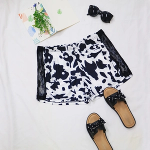 Détail du short motif vache avec dentelle noire et empiècements latéraux transparents