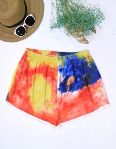 Flat lay of tie-dye beach shorts for women with elastic waist and white hem detailing