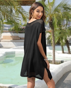 Detail of black crochet beach cover-up featuring side slit and hollow knit pattern