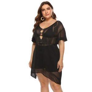 Detail of black crochet beach dress showing hollow-out knit pattern and V-neckline