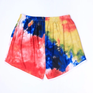 Detail of colorful tie-dye beach shorts with elastic waist and white piping trim