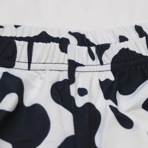 Détail de la taille élastique avec motif vache et coutures renforcées sur le tissu