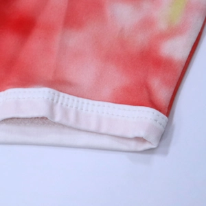 Macro view of women beach shorts featuring red tie-dye fabric and ribbed elastic hem