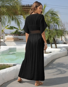 Detailed back view of a long black beach cover-up with hollow lace patchwork design