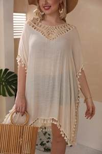 Détail du décolleté au crochet et des franges boho sur une robe de plage beige grande taille