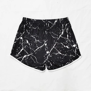 Detail of women's sports shorts with black marble print and white piping trim details