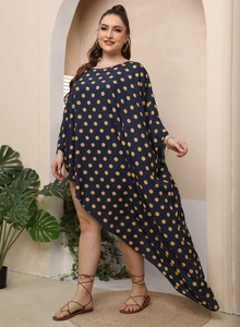 Dettaglio del vestito taglie forti blu scuro a pois gialli con orlo asimmetrico