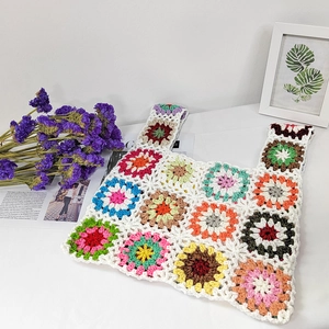 Detail of bohemian crochet tote bag showing handmade knit texture and colorful floral patterns