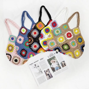 Detail showing five colorful hand-crocheted tote bags with grandmother square floral patterns