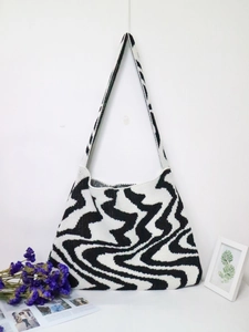 Detailed knit texture of a black and white wavy pattern shoulder tote bag for daily use