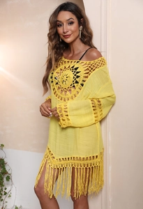Detailansicht eines gelben Häkel-Strandkleids mit Fransen und Sonnenblumen-Strickmuster