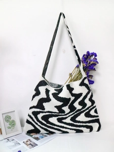 Knitted tote bag with black and white wavy geometric patterns and matching shoulder strap