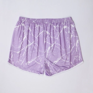 Flat lay of purple marble print beach shorts with white trim and elastic waistband