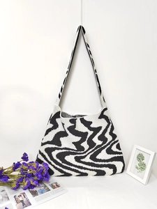 Woven shoulder bag with minimalist black and white irregular wave patterns