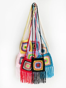 Detail of colorful handmade crochet crossbody bag with fringes and granny square patterns