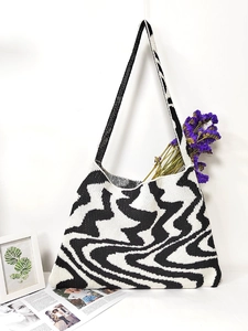 Detail shot of the large knitted tote bag with abstract black and white swirl pattern